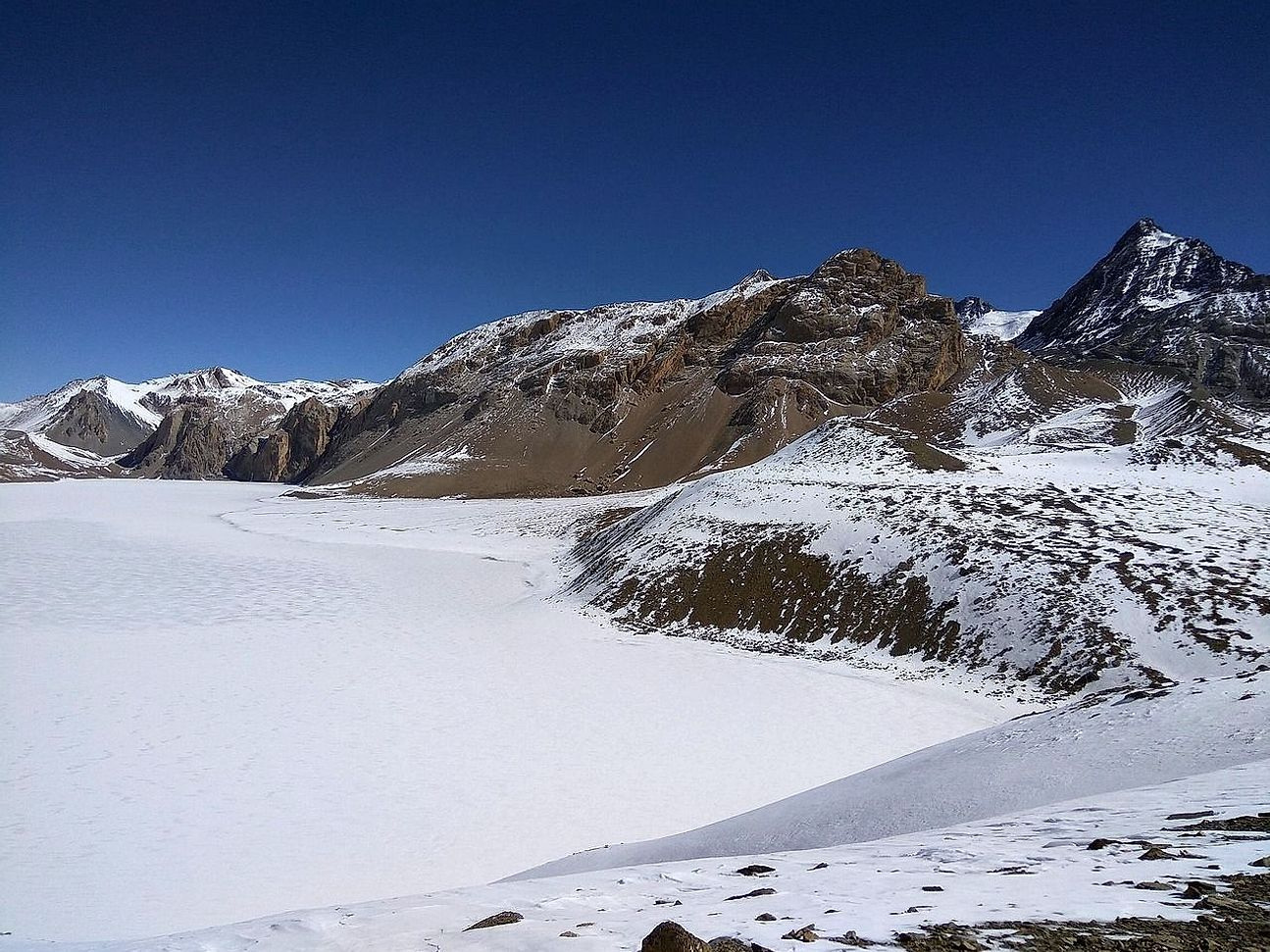 Un lago congelado bajo un cielo que aún no oscurece